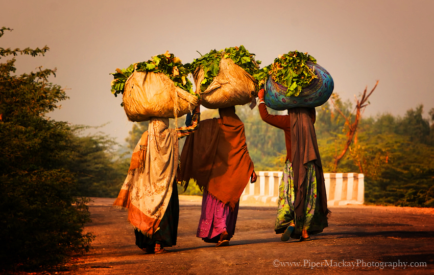 Women carring produce walking alon the highway
