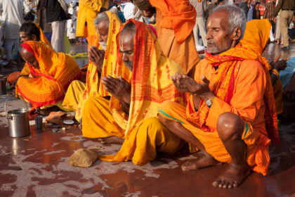 Pilgrims pray after morning bath in Ganges at Kumbh Mela