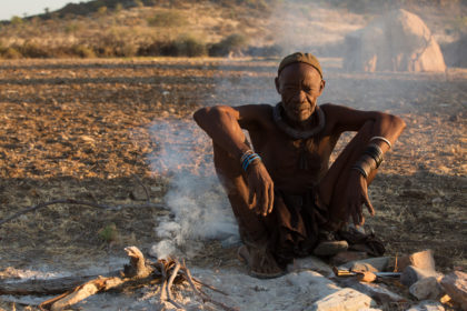 Himba elder around the fire in a village in Angola on a photo tour
