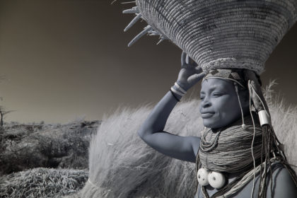 Muwila woman carrying corn husk on her head in Angola on photo tour.