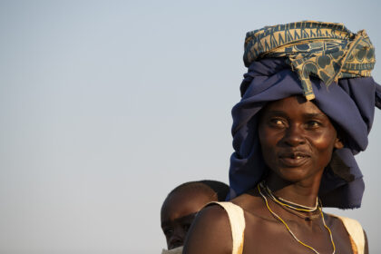 Angola, portrait of a Macubal tribe women with child on her back